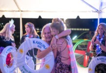 two women hugging each other in front of a tent