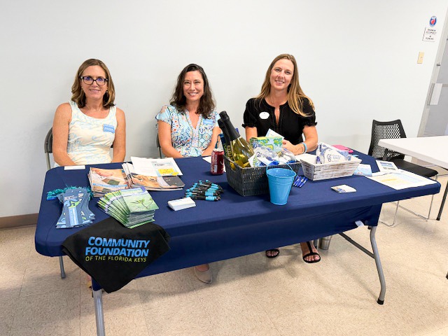 three women sitting at a table with a blue table cloth