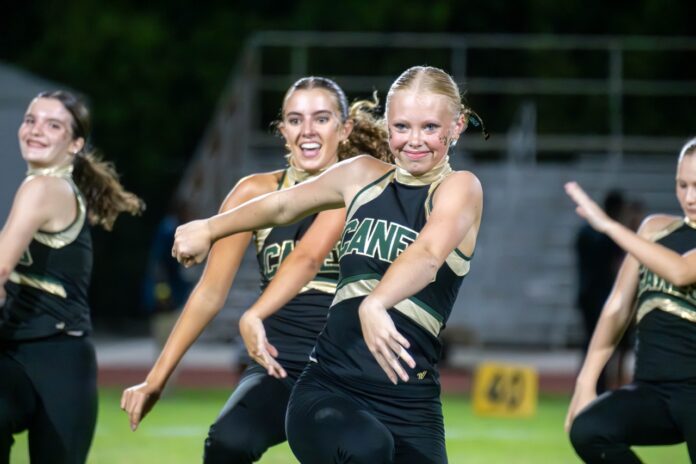 a group of young women standing on top of a field