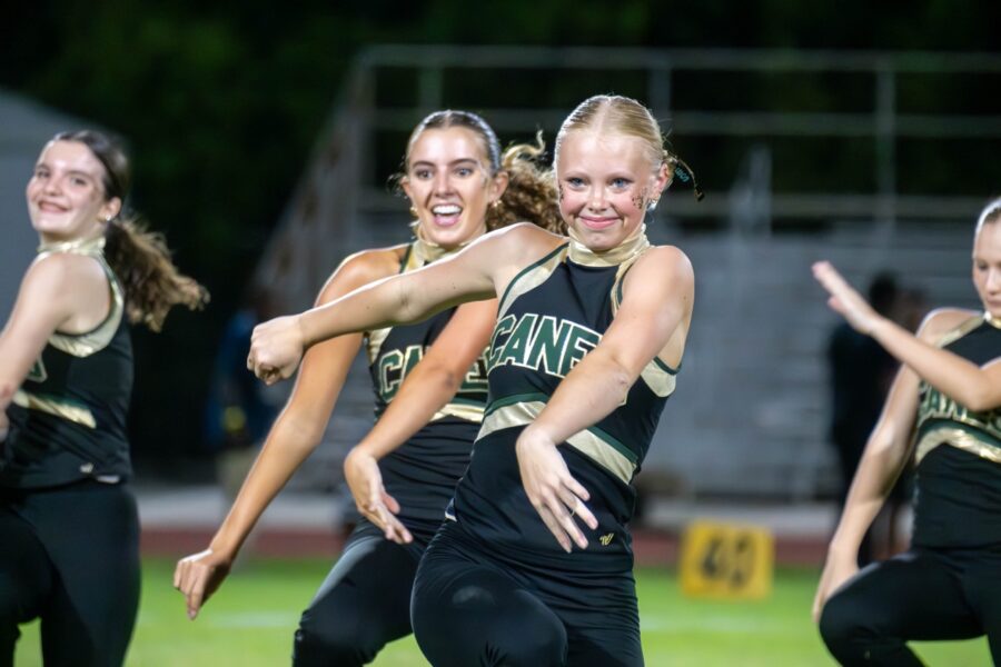 a group of young women standing on top of a field
