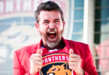 a man in a red jacket is holding a shirt
