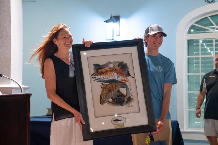 Casting for Cats 2 a man and a woman holding a framed picture