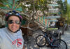 a man wearing a helmet and sunglasses standing next to a bicycle