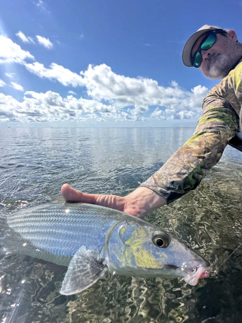 a man holding a fish in the water