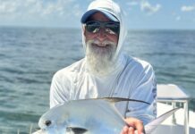 a man sitting on a boat holding a fish