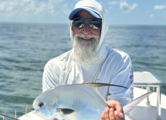 FLORIDA KEYS FISH REPORT: FALL FISHING BRINGS ITS OWN COLOR CHANGE TO FLORIDA BAY a man sitting on a boat holding a fish