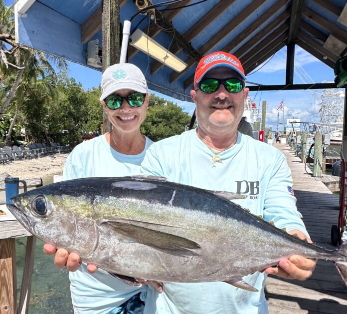 Clients with blackfin tuna two men holding a fish on a dock