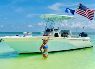 a woman standing in the water next to a boat