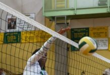 a volleyball player hitting a ball over the net