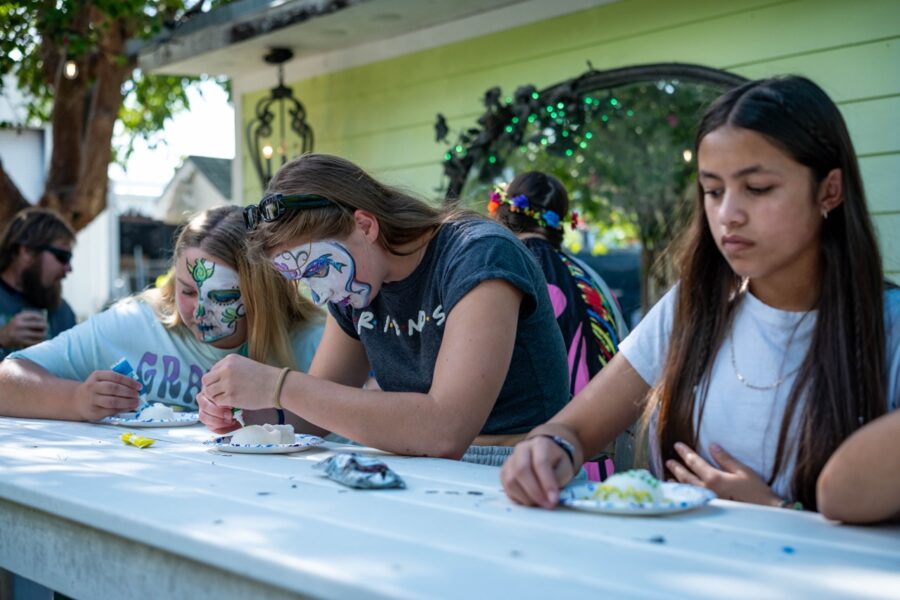 a group of girls sitting at a table with face paint
