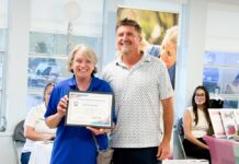 a man standing next to a woman holding an award