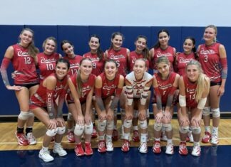 a group of women's volleyball players posing for a team photo