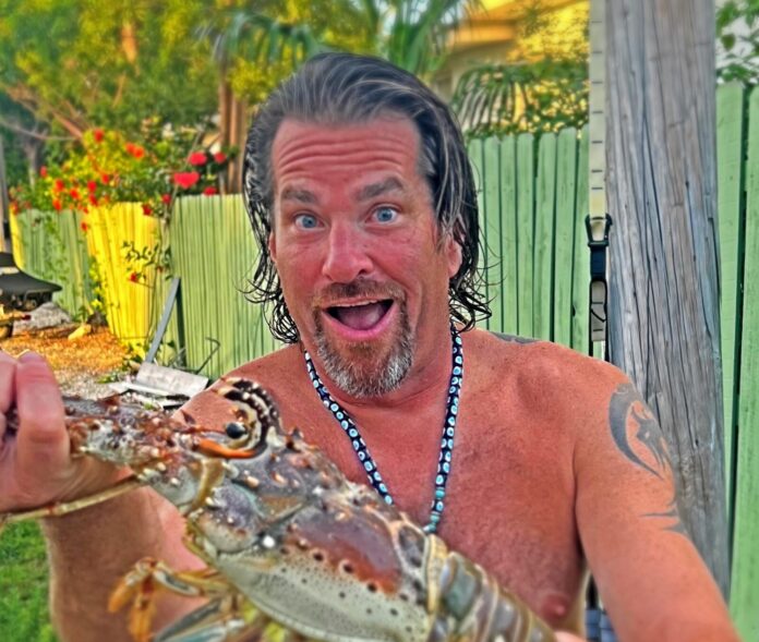 a man holding a large lobster in his hand