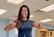 a woman giving a thumbs up in an office