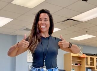 a woman giving a thumbs up in an office