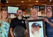 a group of people holding a picture of a man with a beard