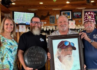 a group of people holding a picture of a man with a beard