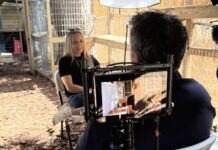 a woman sitting in a chair in front of a camera