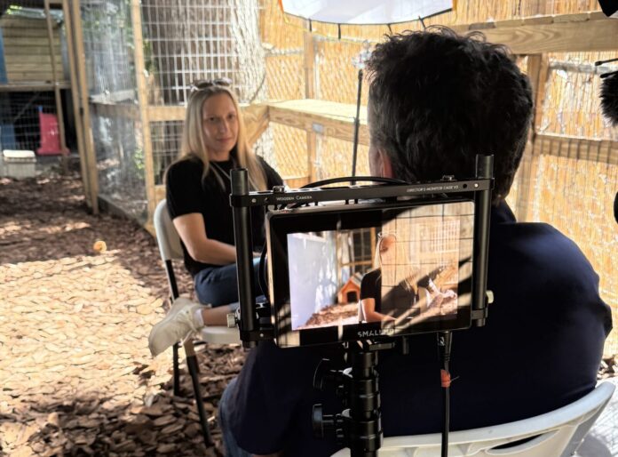 a woman sitting in a chair in front of a camera