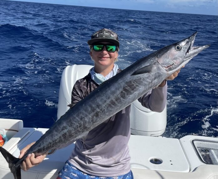IMG_4976 a man on a boat holding a large fish