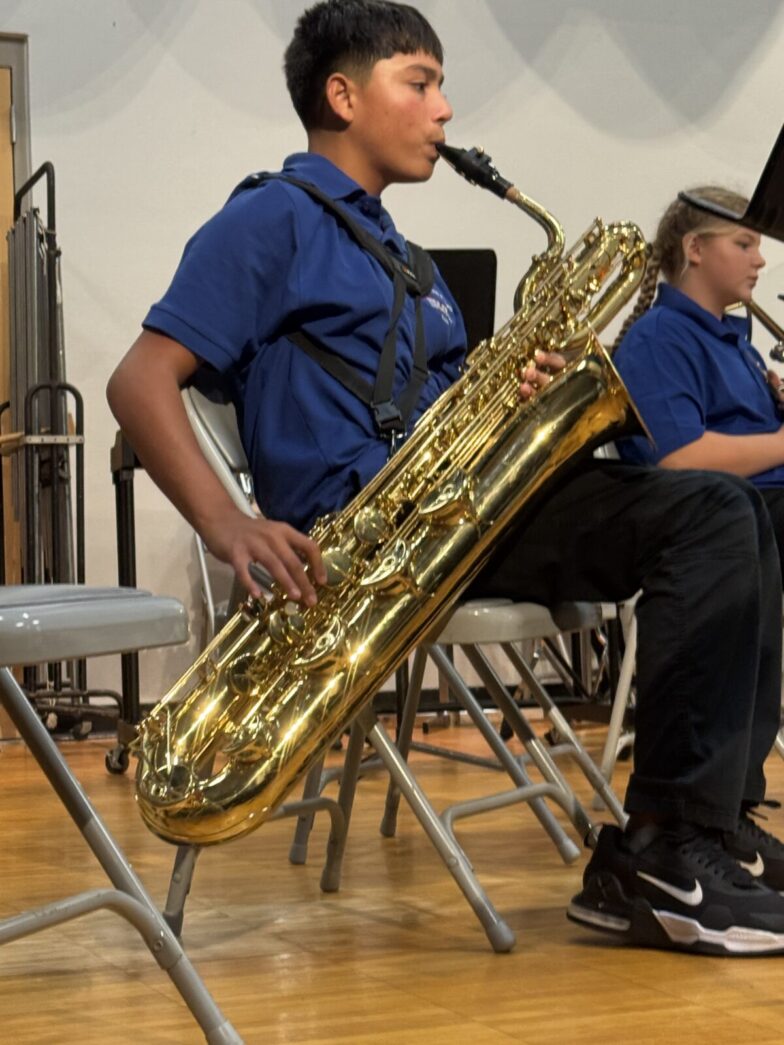 a young man playing a saxophone on a stage