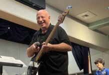 SUGARLOAF BAND MAKES MUSIC  a man standing on a stage with a guitar