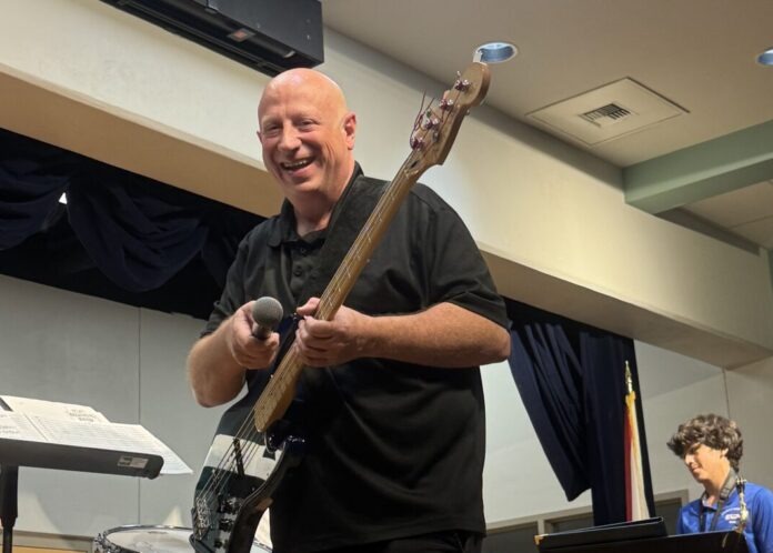 a man standing on a stage with a guitar