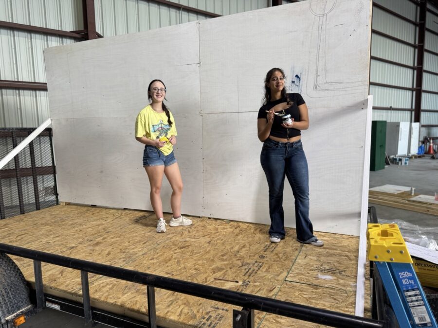 a couple of women standing on top of a wooden platform