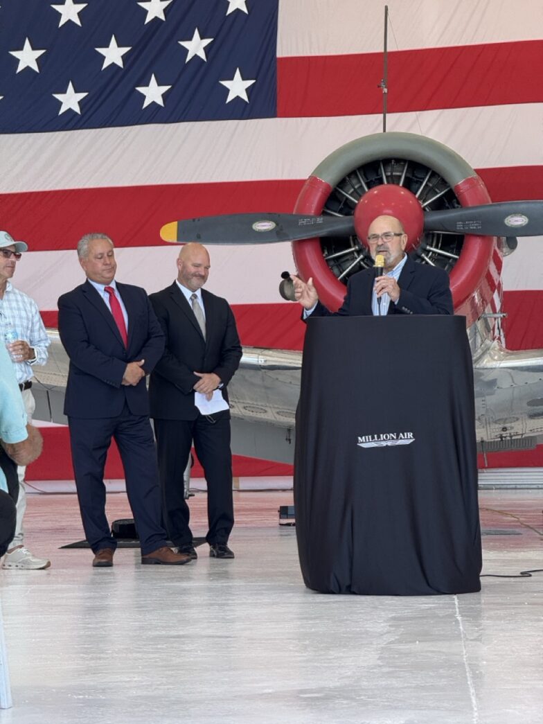 a man standing at a podium in front of an american flag