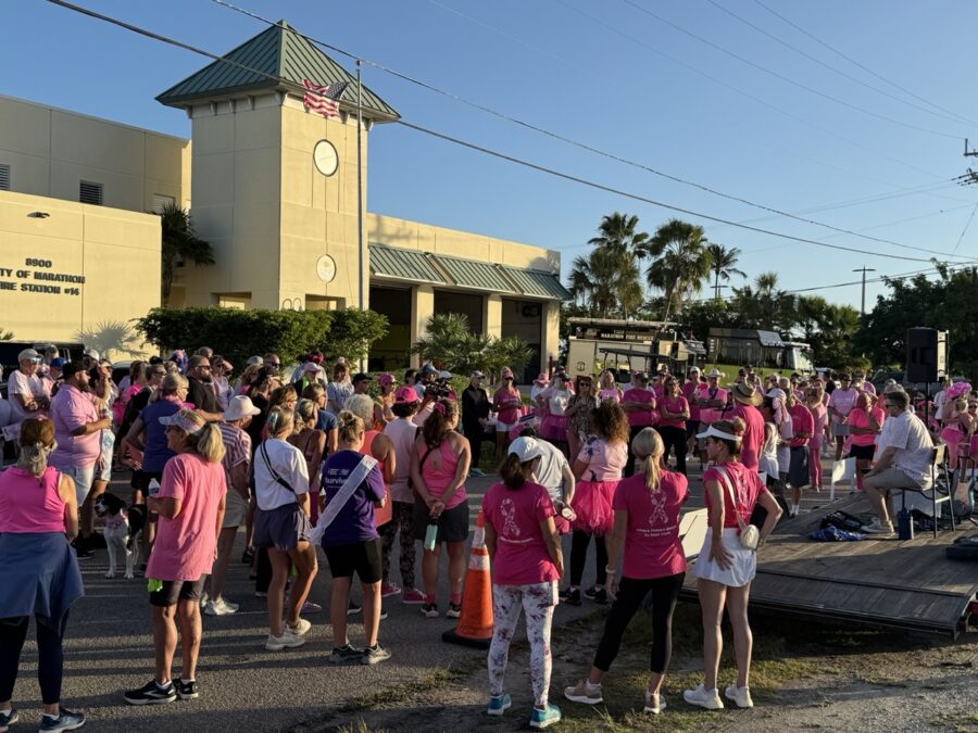 a group of people in pink shirts standing in front of a building