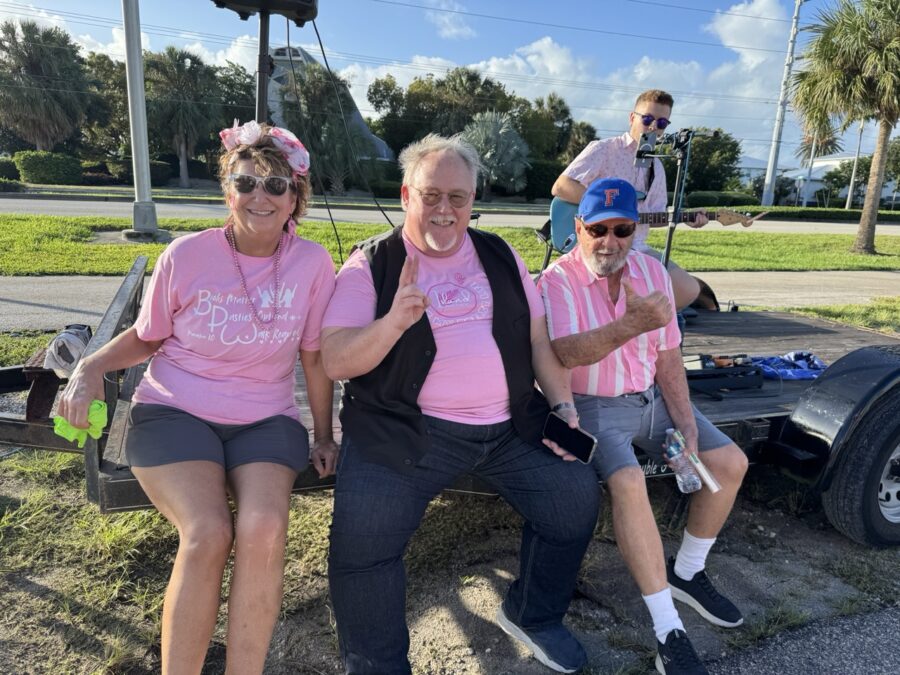 a group of people in pink shirts sitting on a trailer