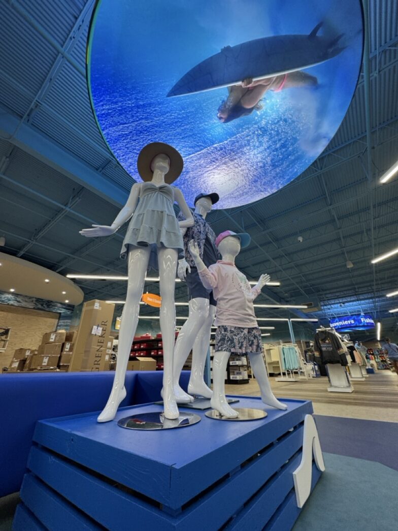 a group of mannequins are standing on a blue platform