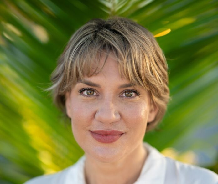 IMG_7835 a woman with short hair wearing a white shirt