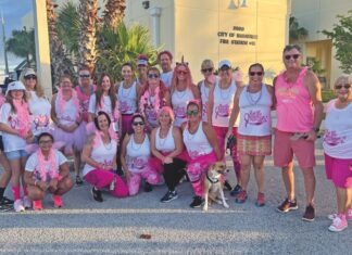 a group of women in pink and white shirts posing for a picture