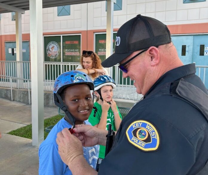 Image 9 Large a police officer helping a young boy put on his helmet