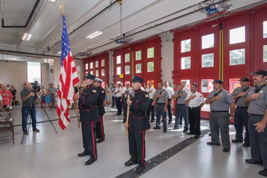 a group of men in uniform standing in front of a flag