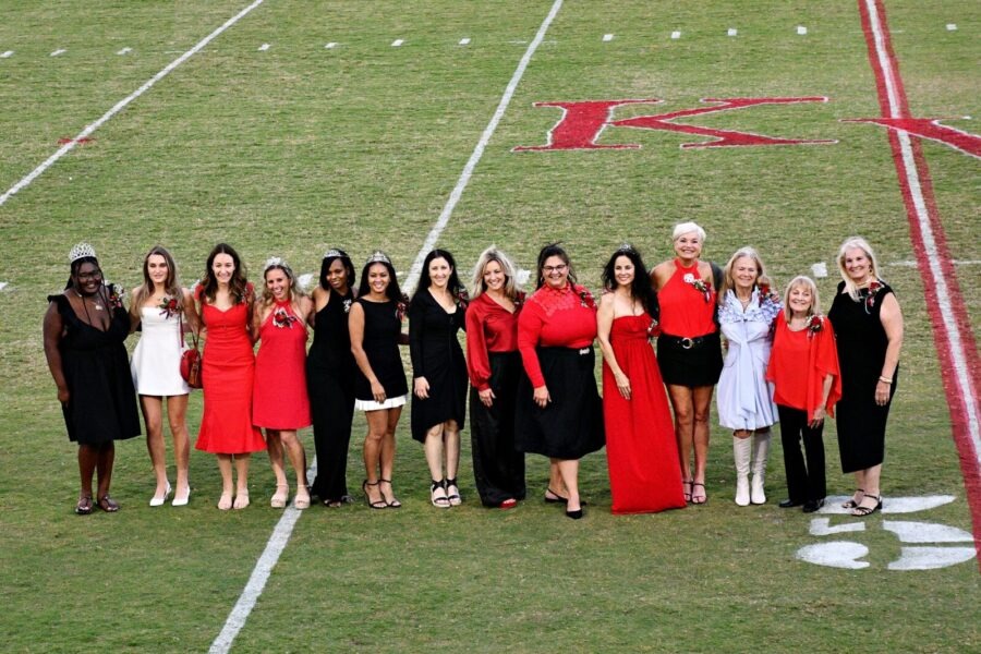 a group of women standing on top of a field
