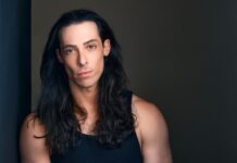 a man with long hair and a black tank top