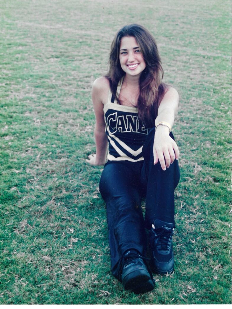 a woman sitting on the ground in a field
