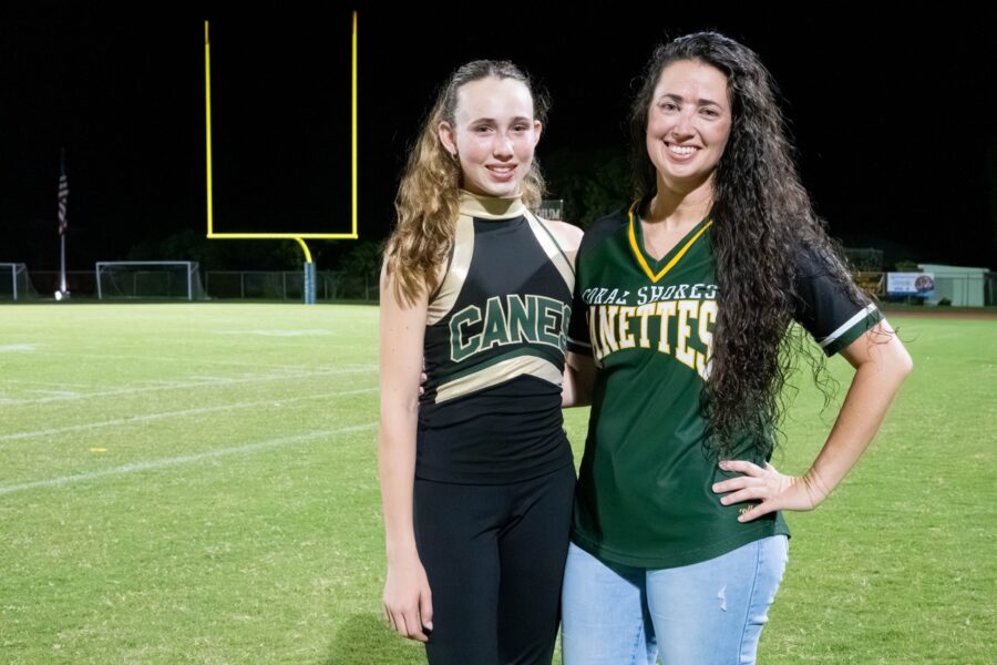 a couple of women standing next to each other on a field