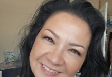 a woman with long black hair smiling at the camera