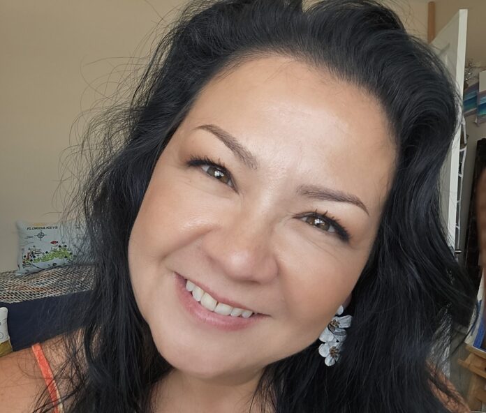 Lily a woman with long black hair smiling at the camera