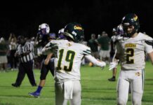 a couple of football players standing on top of a field