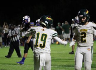 a couple of football players standing on top of a field