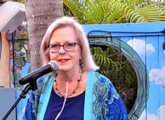 COMMISSIONER ABSENCES COULD LEAD TO REMOVAL a woman standing in front of a microphone