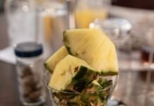 a glass filled with fruit on top of a wooden table
