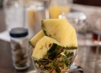 WHAT’S COOKING, KEY WEST? ‘RUM REVELATION’ ENHANCES FANTASY FEST REVELRY a glass filled with fruit on top of a wooden table