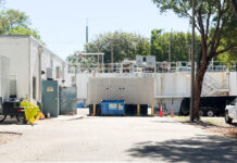 a white building with a lot of trees in front of it