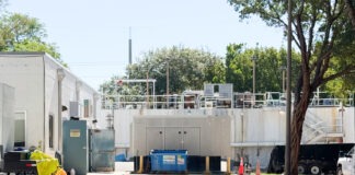 a white building with a lot of trees in front of it