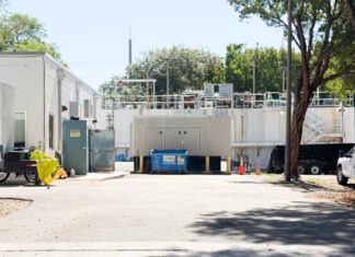 a white building with a lot of trees in front of it